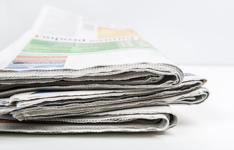 A close-up of a stack of newspapers.